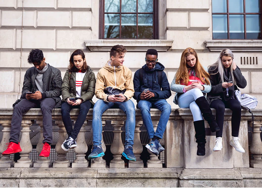 Group of youth sitting on a wall.